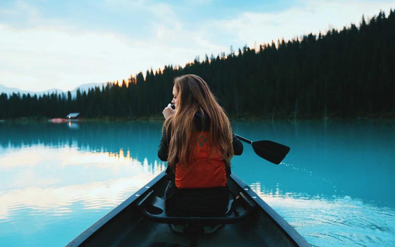 Original photo of a woman paddling a canoe on a mountain lake