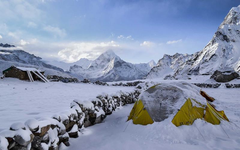 AI-generated image of a mountain base camp at dusk with glowing tents in falling snow